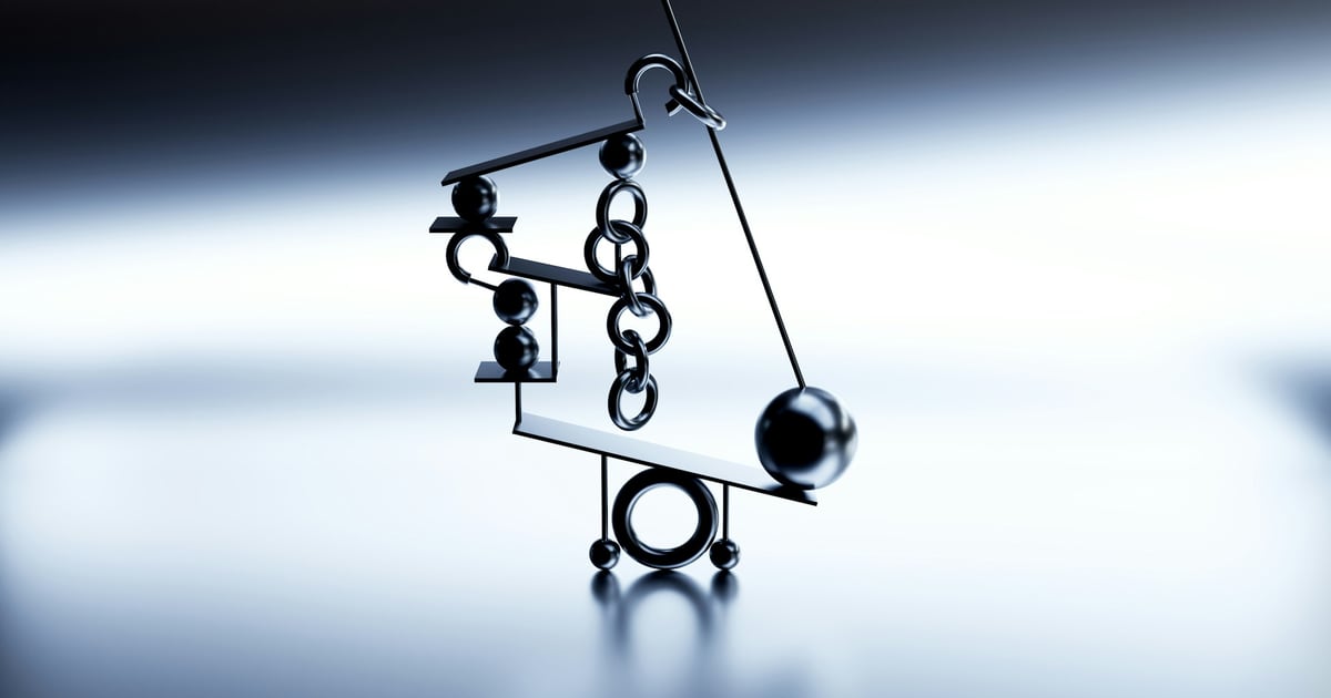 A metal balancing sculpture of rings, chains and a ball on a pivot, lit against a pale blue background