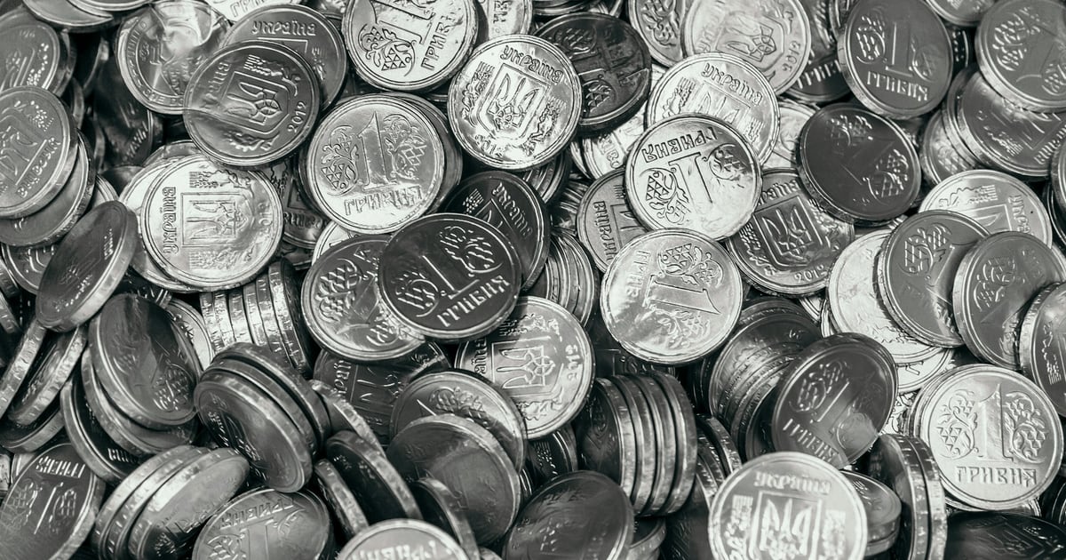 A black-and-white pile of many small coins, filling the frame edge to edge